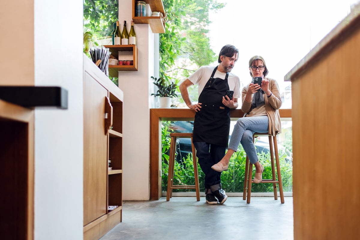 Cafe owner consulting with a financial advisor using a smartphone