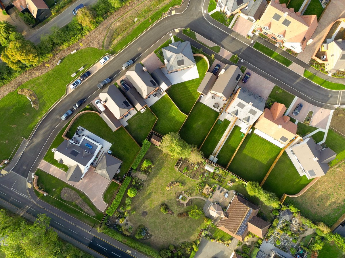 Drone top down view of newly purchased homes seen in a British housing development site. Smaller, first time buyer homes are on the right, further into the estate.