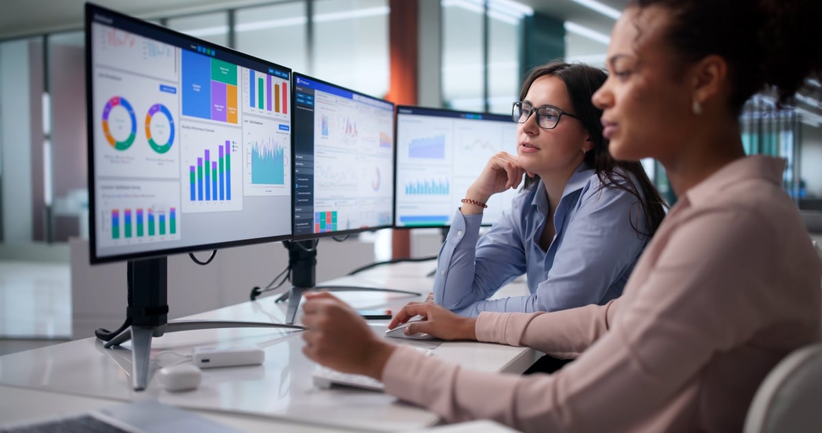 Diverse women on analytics team analyzing financial data at office